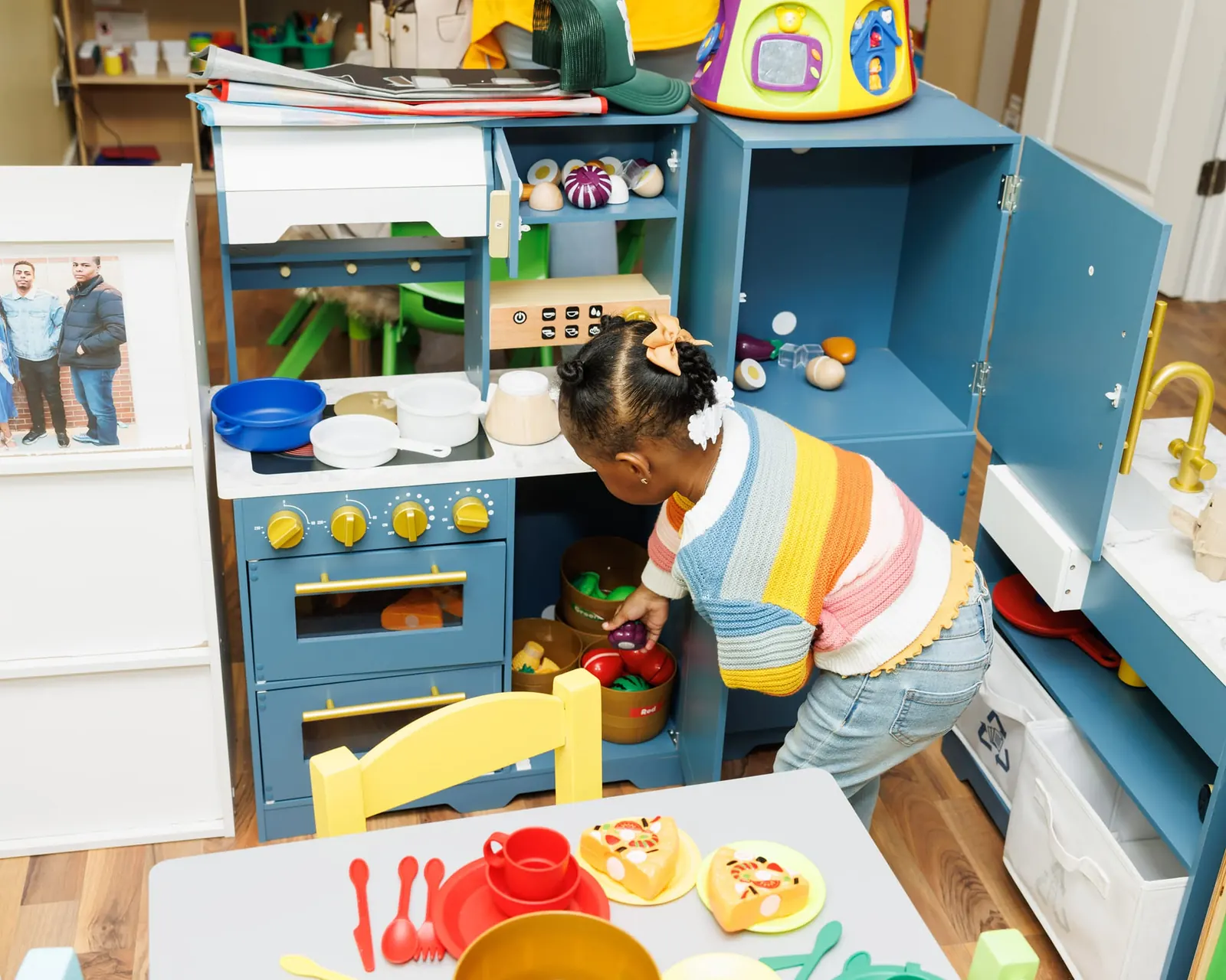 Child cooking up a pretend meal in the play kitchen