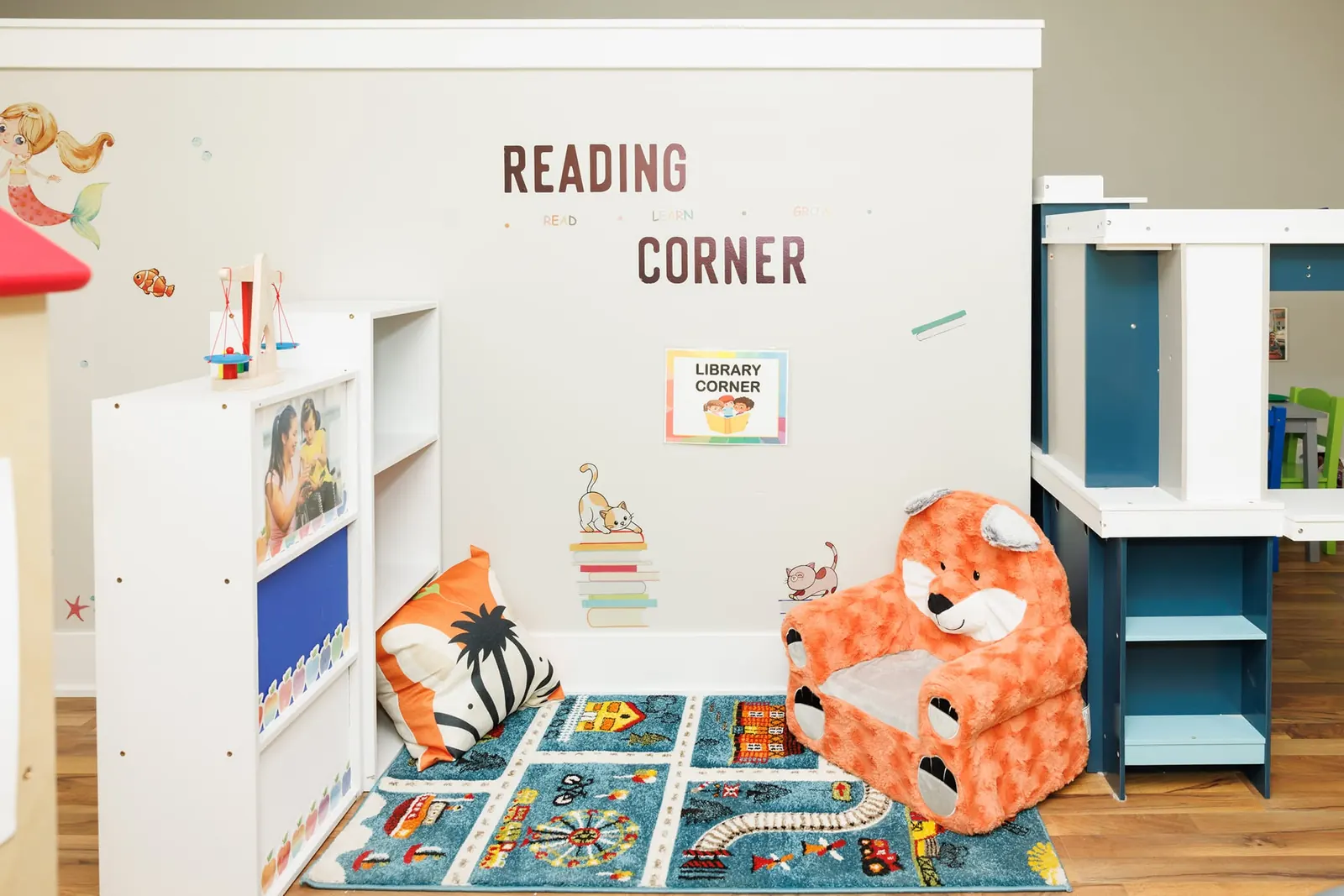 Reading corner with bookshelves, a fox armchair and a road play rug